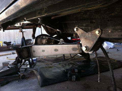 1995 Ford Bronco - Close-up view of the undercarriage, focusing on suspension components and a metal fuel tank. The Supermotors.net logo is visible in the low…