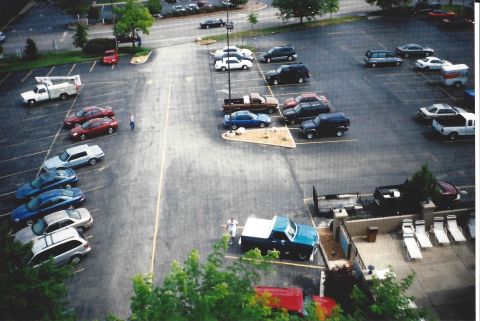1982 Ford Bronco - An aerial view captures a busy parking lot filled with various vehicles under a daytime sky.