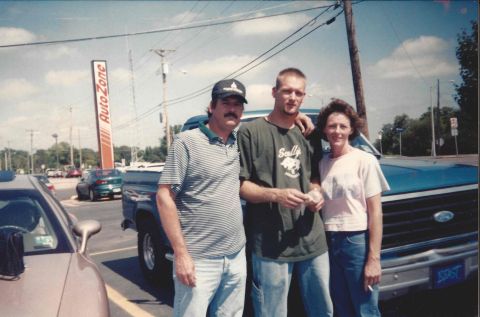 1982 Ford Bronco - A family poses for a photo in front of a blue Ford truck, with an AutoZone sign visible in the background.
