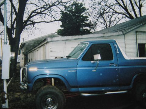 1982 Ford Bronco - A blue Ford Bronco is seen from the front quarter angle, modified for off-road use.