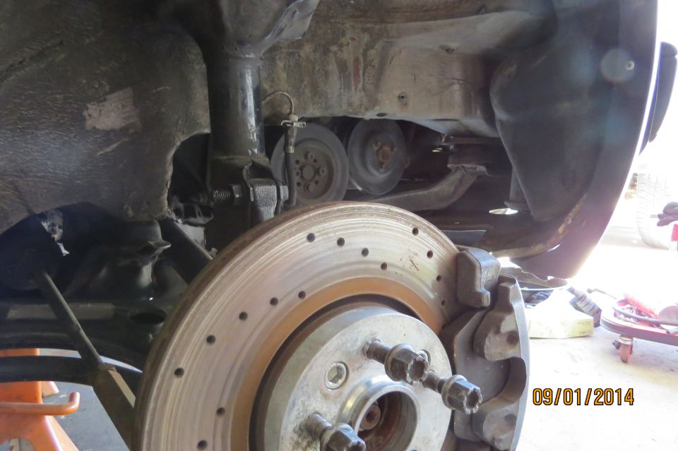 Car's front brake rotor and suspension components, viewed from below