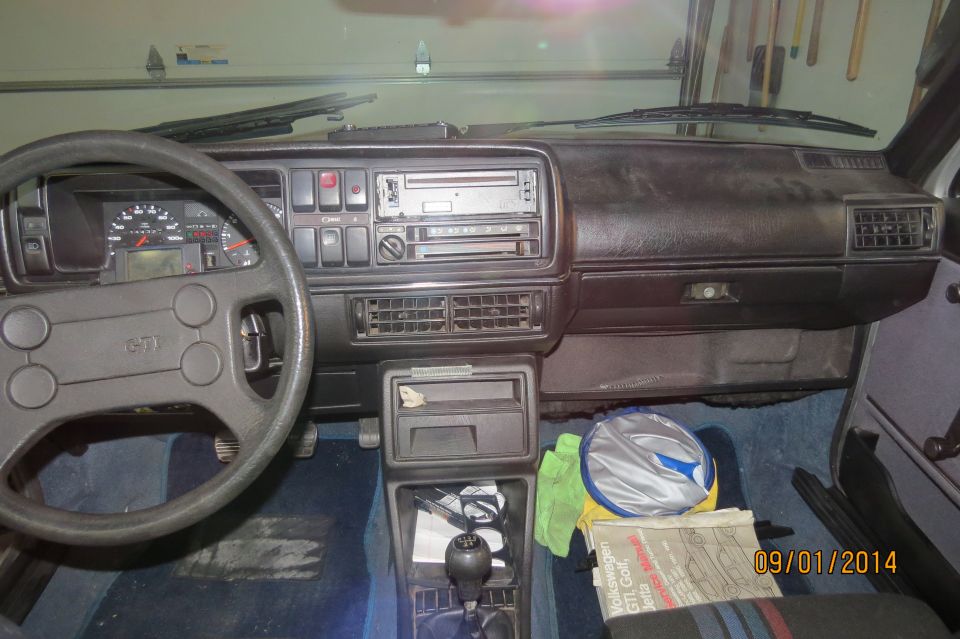 Dashboard and steering wheel of a 1985 Volkswagen GTI. Steering wheel has a GTI emblem