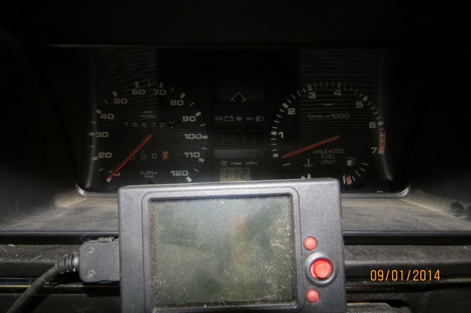 Dashboard gauges with aftermarket device, showing 154321 miles