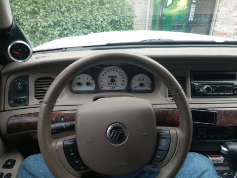 2000 Mercury Grand Marquis - Interior view of a 2000 Mercury Grand Marquis, a steering wheel, dashboard, and an added gauge.