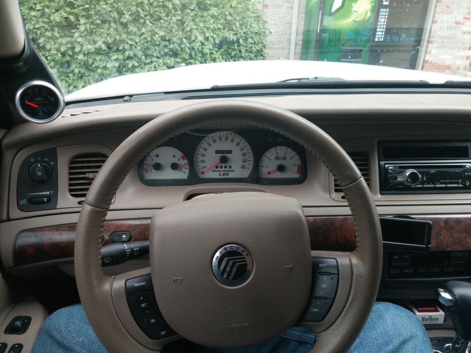 2000 Mercury Grand Marquis interior showing dashboard, steering wheel, and aftermarket gauge