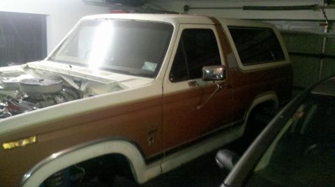 1982 Ford Bronco - The engine bay of a 1982 Ford Bronco, a two-tone brown and white exterior.