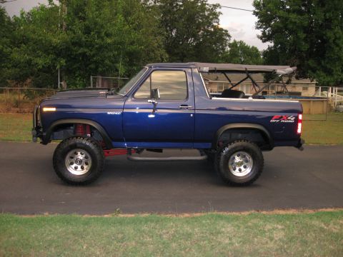 1982 Ford Bronco - This lifted, blue Ford Bronco features a removable soft top and off-road tires.