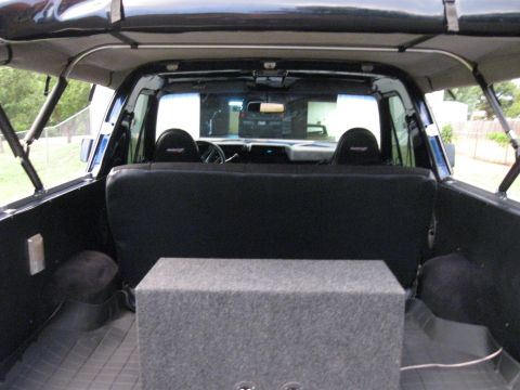 1982 Ford Bronco - Interior view of a 1982 Ford Bronco, showing the rear seating area and a large subwoofer box.