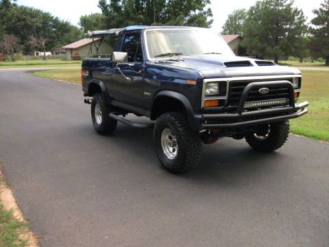 1982 Ford Bronco - Blue Ford Bronco with aftermarket bumper and light bar.