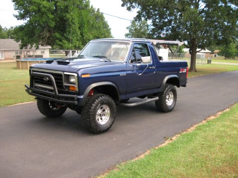 1982 Ford Bronco - This blue 1982 Ford Bronco features a custom front bumper with an integrated light bar and a prominent hood scoop.