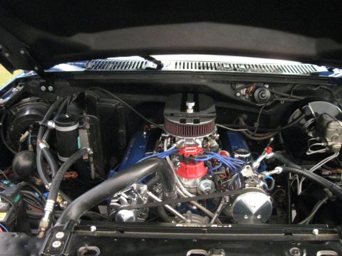 1982 Ford Bronco - Engine bay of a vehicle with blue valve covers and a red distributor cap.