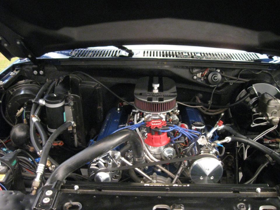 Engine bay with blue valve covers and a red distributor cap. Chrome air cleaner is visible