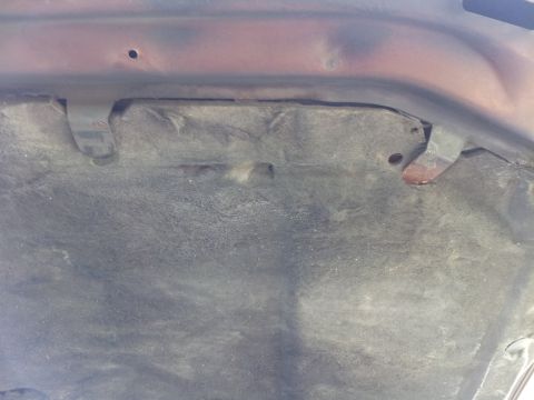 1980 Ford Mustang - The underside of a vehicle's hood, showing the insulation material and attachment hardware.