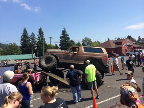 1989 Ford Bronco - A lifted 1989 Ford Bronco is showcased at an off-road show, drawing a crowd.