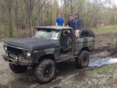 1979 Ford Bronco - Modified 1978 Ford F-150 pickup truck with camouflage paint stuck in a muddy area.