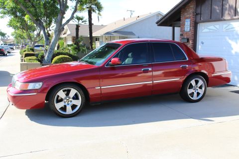 2002 Mercury Grand Marquis - This red 2002 Mercury Grand Marquis sedan is parked in a suburban driveway.