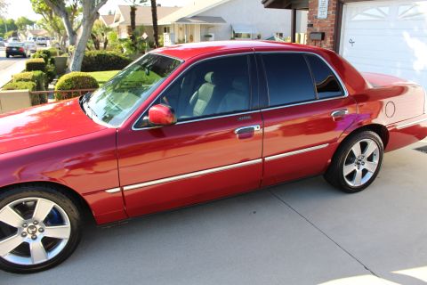2002 Mercury Grand Marquis - A red 2002 Mercury Grand Marquis is shown from the side in a suburban driveway.