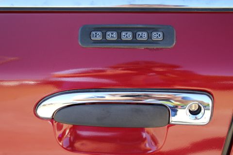 2002 Mercury Grand Marquis - Keypad entry system on the driver's side door of a red 2002 Mercury Grand Marquis.