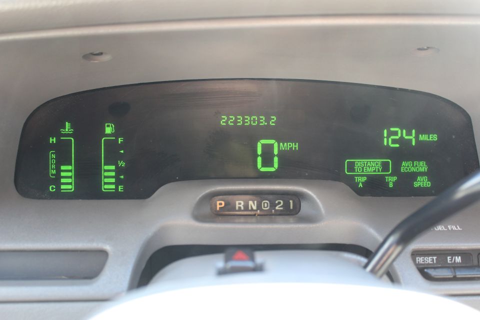 Digital dashboard gauges showing 0 MPH, 223303.2 miles, fuel and temperature levels, and trip information