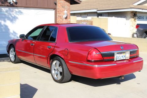2002 Mercury Grand Marquis - This red sedan has a custom license plate that reads 'EVIL MGM'.