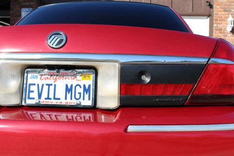 2002 Mercury Grand Marquis - The rear of a red Mercury Grand Marquis is shown, its license plate and taillights.