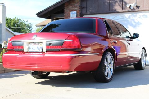 2002 Mercury Grand Marquis - Rear view of a red 2002 Mercury Grand Marquis sedan parked in a driveway.