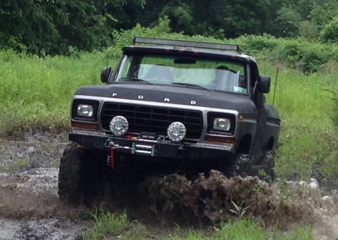 1979 Ford Bronco - This modified Ford F-150 is navigating a muddy off-road trail.