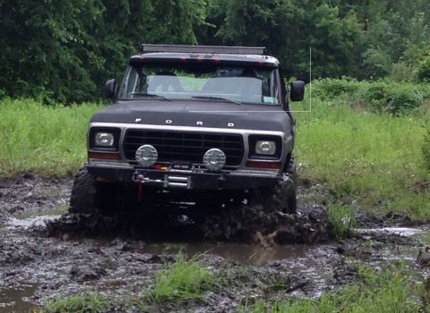 1979 Ford Bronco - This dark-colored Ford Bronco navigates a muddy off-road trail.