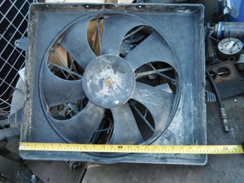 1980 Ford Bronco - A radiator fan is shown with a tape measure indicating its size. Other items are visible in the background.