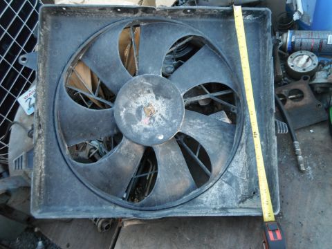 1980 Ford Bronco - A radiator fan is shown with a measuring tape for scale, and a partial sticker on the left side.