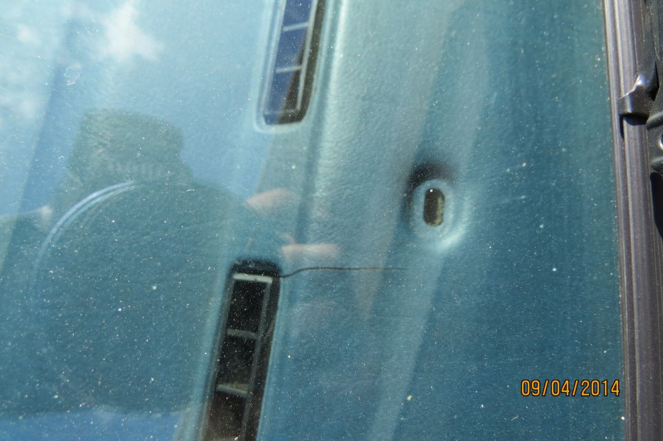 Close-up of teal car paint with reflection of driver and dashboard; date stamp 09/04/2014