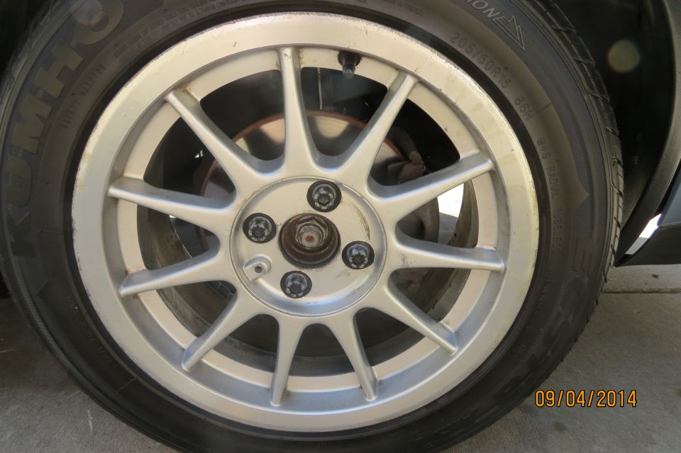 Close-up of a silver multi-spoke wheel and tire. Date stamp in corner