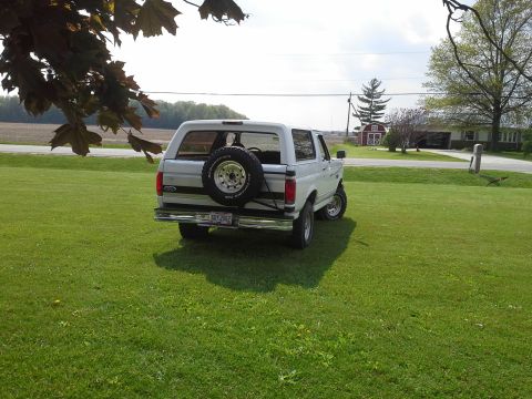 1996 Ford Bronco - This 1996 Ford Bronco is seen from the rear, parked on a grassy lawn with a spare tire on the tailgate.