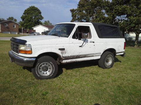 1996 Ford Bronco - This white 1996 Ford Bronco has a black soft top and is covered in mud splatters.