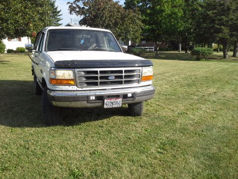 1996 Ford Bronco - This white Ford truck is parked on a grassy lawn with trees in the background.