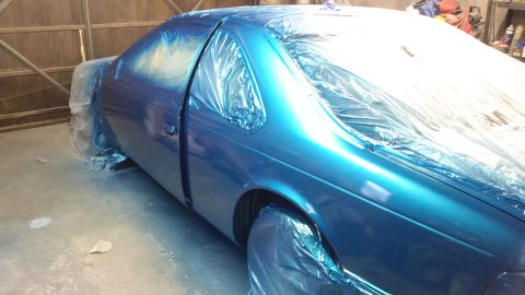 1994 Ford Thunderbird - A blue 1994 Ford Thunderbird is being prepped for painting, with plastic sheeting covering most of the vehicle.
