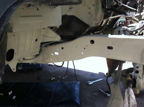 1995 Ford Bronco - Close-up view of vehicle frame and suspension components, with tools visible on the ground.