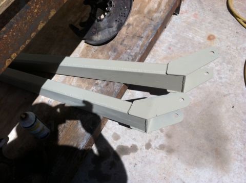 1995 Ford Bronco - Painted suspension parts sit on a workbench next to a brake rotor and a can of spray paint.