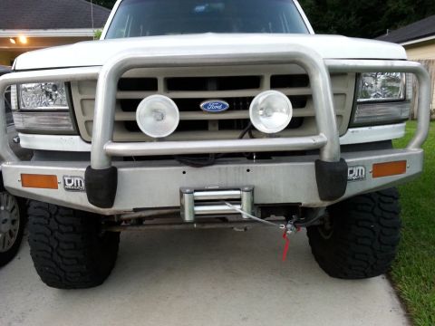1992 Ford Bronco - Frontal view of a white Ford Bronco equipped with a winch and bull bar.