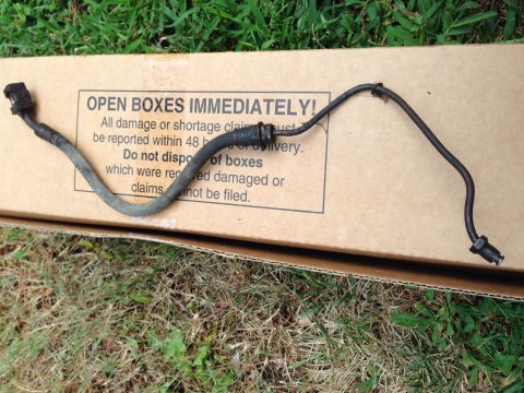 1979 Ford Bronco - A single brake line is shown resting on a cardboard box with "OPEN BOXES IMMEDIATELY!" printed on it.