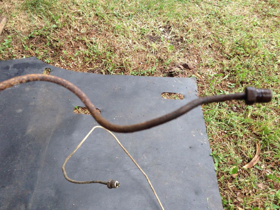 Rusty metal brake line on black mat