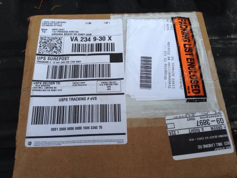 1979 Ford Bronco - This image shows a cardboard box covered in various shipping labels and tracking information.