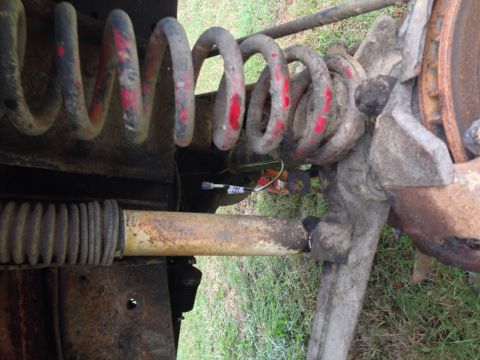 1979 Ford Bronco - Close-up of a vehicle's suspension system, showing a coil spring and shock absorber.