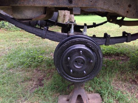 1979 Ford Bronco - The rear suspension and braking system of a vehicle are shown, supported by jack stands for maintenance.