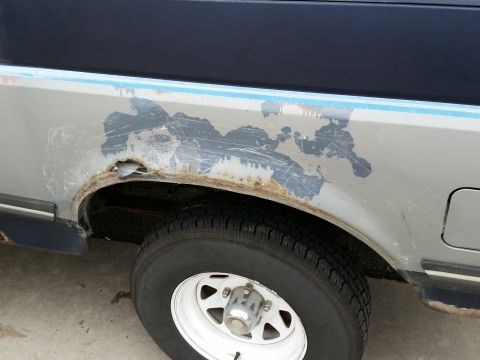 1988 Ford Bronco - This 1988 Ford Bronco displays extensive rust around the rear wheel well, indicating significant body deterioration.
