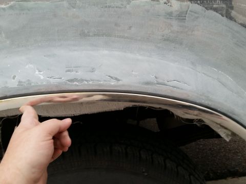 1988 Ford Bronco - Close-up of a vehicle's wheel well showing chrome trim and a fiberglass repair in progress.