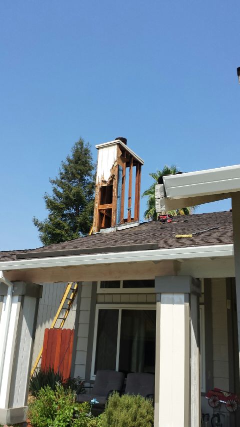 1989 Ford Bronco - A house chimney is undergoing repairs, with its outer structure partially removed to expose the wooden frame.