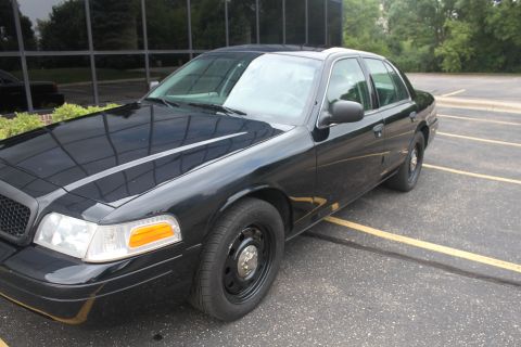 2009 Ford Crown Victoria - This black 2009 Ford Crown Victoria sedan is viewed from the front three-quarter angle in a parking lot.