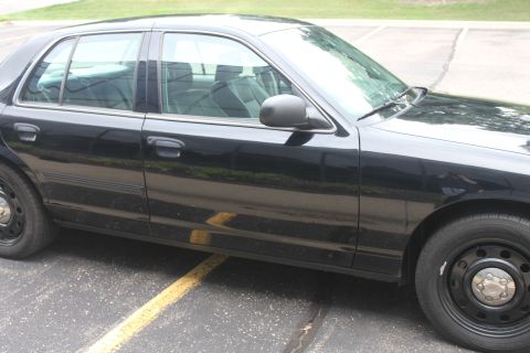 2009 Ford Crown Victoria - Side profile of a black 2009 Ford Crown Victoria sedan parked on asphalt.