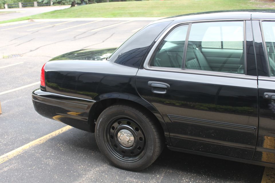 Black sedan parked in a lot, showing the rear passenger side